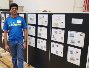 a man standing in a room: Hemanth V. Setty with his display of TALPEX Show Special covers released since 1975.